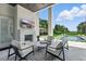 Outdoor living room with a fireplace, television, and a view to the pool at 9259 Tibet Pointe Cir, Windermere, FL 34786