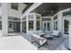 Elegant outdoor patio with stylish seating, marble floors, black trim windows, and a comfortable lounge area at 9259 Tibet Pointe Cir, Windermere, FL 34786