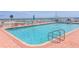 Inviting community pool surrounded by lounge chairs and umbrellas with ocean views at 935 S Atlantic Ave # 244, Daytona Beach, FL 32118