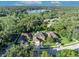Stunning aerial view of a brick home with a well-manicured lawn in a lush, green neighborhood near a lake at 9455 Belmont Ter, Oviedo, FL 32765