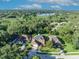 Aerial view highlights the beautiful home amidst lush greenery and a distant lake, capturing its serene setting at 9455 Belmont Ter, Oviedo, FL 32765