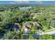 Overhead view displays a brick home with nearby lake and surrounded by lush greenery and neighborhood at 9455 Belmont Ter, Oviedo, FL 32765
