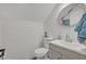 This half bath offers a white beadboard wall, round mirror, and grey vanity with a white countertop at 9455 Belmont Ter, Oviedo, FL 32765