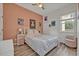 Bedroom with pink accent wall, ceiling fan, wood floors, and bright natural light at 9455 Belmont Ter, Oviedo, FL 32765