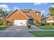 Charming two-story brick home with a well-manicured front yard, a garage, and a welcoming blue front door at 9455 Belmont Ter, Oviedo, FL 32765