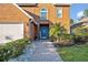 Inviting brick pathway leading to a charming blue front door with decorative accents and lush landscaping at 9455 Belmont Ter, Oviedo, FL 32765