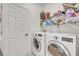 Laundry room with white washer and dryer, wire shelving, and door to the hallway at 9455 Belmont Ter, Oviedo, FL 32765