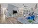 Spacious living room featuring wood-look floors, a blue accent wall, and double doors to the backyard at 9455 Belmont Ter, Oviedo, FL 32765