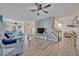 Spacious living room featuring wood-look floors, a stylish sofa, and an open staircase at 9455 Belmont Ter, Oviedo, FL 32765