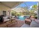 Covered pool and spa area featuring lounge seating and manicured landscaping at 9455 Belmont Ter, Oviedo, FL 32765