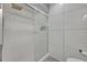 Shower with glass door, white tiling, modern shower head, and recessed shower caddy at 9455 Belmont Ter, Oviedo, FL 32765