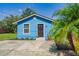 Charming blue one-story home with a well-kept lawn and freshly painted front door at 1002 S Locust Ave, Sanford, FL 32771
