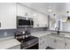 Updated kitchen with stainless appliances, white cabinetry, and sleek hardware at 1002 S Locust Ave, Sanford, FL 32771