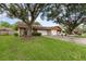 Exterior view of home with large trees, a green lawn, and an attached garage at 106 Water Oak Dr, Sanford, FL 32773