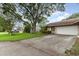 Exterior elevation of home featuring a lawn, mature trees, and an attached garage at 106 Water Oak Dr, Sanford, FL 32773