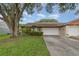 Charming single-story home featuring an attached two-car garage, mature trees, and lovely landscaping at 106 Water Oak Dr, Sanford, FL 32773
