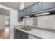 Galley kitchen featuring gray cabinets, stainless steel sink, and light countertops at 106 Water Oak Dr, Sanford, FL 32773