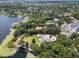 Expansive aerial view of a lakeside home featuring a pool, surrounded by lush greenery and neighboring properties at 1112 Preserve Point Dr, Winter Park, FL 32789