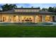 Beautifully lit back exterior featuring a luxurious pool and covered patio for evening enjoyment and entertaining at 1112 Preserve Point Dr, Winter Park, FL 32789