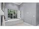 Bathroom featuring a soaking tub, marble surround, and outside views at 1112 Preserve Point Dr, Winter Park, FL 32789