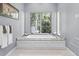 Bathroom featuring a soaking tub, marble surround, and outside views at 1112 Preserve Point Dr, Winter Park, FL 32789