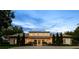 Elegant exterior of a home with landscaped grounds, featuring a circular driveway and beautiful architectural lighting at 1112 Preserve Point Dr, Winter Park, FL 32789