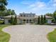 A stately home featuring a circular driveway, manicured landscaping, and symmetrical design elements at 1112 Preserve Point Dr, Winter Park, FL 32789
