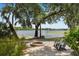 Scenic lakeside brick patio featuring a charming stone fire pit and Adirondack chairs for outdoor relaxation at 1112 Preserve Point Dr, Winter Park, FL 32789