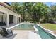 Inviting pool with a luxurious sun shelf, lush landscaping and covered patio at 1112 Preserve Point Dr, Winter Park, FL 32789