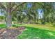 Lush backyard with mature trees, mulch bed, and well-maintained lawn provides scenic views at 11602 Graces Way, Clermont, FL 34711