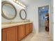 Bathroom with double sinks, a doorway to the shower, light blue walls and tile floors at 11602 Graces Way, Clermont, FL 34711
