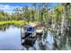 Picturesque boat dock with a covered slip in a serene, tree-lined waterfront setting at 11602 Graces Way, Clermont, FL 34711