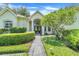 Inviting entryway featuring a brick walkway, manicured bushes, and a charming front door at 11602 Graces Way, Clermont, FL 34711