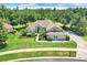 Beautiful single-story home showcasing a well-manicured lawn, lush landscaping, and a brick driveway at 11602 Graces Way, Clermont, FL 34711