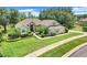 Charming single-story home featuring a lush green lawn and meticulously manicured landscaping at 11602 Graces Way, Clermont, FL 34711
