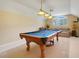 Game room with pool table, overhead lights and a comfortable couch at 11602 Graces Way, Clermont, FL 34711