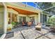 Charming covered patio with flagstone flooring and comfortable seating area with a ceiling fan at 11602 Graces Way, Clermont, FL 34711