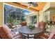 Covered patio features a decorative table, chairs, and scenic views of the outdoors at 11602 Graces Way, Clermont, FL 34711