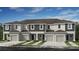 Charming townhome boasts modern architecture, attached garages, and tidy landscaping under a bright blue sky at 130 River Front Way, Edgewater, FL 32141