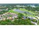 Aerial view of a golf course community featuring a lake and upscale homes surrounded by trees at 1365 Tappie Toorie Cir, Lake Mary, FL 32746