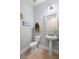 Powder room features pedestal sink, toilet, light fixture and coastal themed decor at 1365 Tappie Toorie Cir, Lake Mary, FL 32746