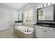 Elegant bathroom featuring a soaking tub, dual vanities, and natural light from a large window at 1365 Tappie Toorie Cir, Lake Mary, FL 32746