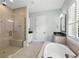 Bright bathroom featuring a glass shower, soaking tub, granite countertops, and white cabinetry at 1365 Tappie Toorie Cir, Lake Mary, FL 32746