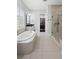 Bright bathroom features a glass shower, soaking tub, walk in closet, and neutral tile at 1365 Tappie Toorie Cir, Lake Mary, FL 32746