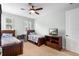 A cozy bedroom features two beds, a wooden dresser with a TV, and natural light from the windows at 1365 Tappie Toorie Cir, Lake Mary, FL 32746