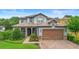 Charming two-story home featuring a well-manicured lawn, brick driveway, and a cozy front entrance at 1365 Tappie Toorie Cir, Lake Mary, FL 32746