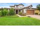 Charming two-story home featuring a manicured lawn, mature landscaping, and a cozy front porch at 1365 Tappie Toorie Cir, Lake Mary, FL 32746
