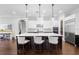 Modern kitchen with a large island, pendant lighting, white cabinets, and stainless steel appliances at 1365 Tappie Toorie Cir, Lake Mary, FL 32746