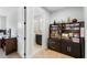 Well-organized office space with built-in shelving and a glimpse of the ensuite bathroom at 1365 Tappie Toorie Cir, Lake Mary, FL 32746