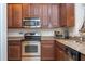 A kitchen with stainless steel appliances, granite countertops, and wooden cabinets at 14231 Desert Haven St # Ge, Windermere, FL 34786